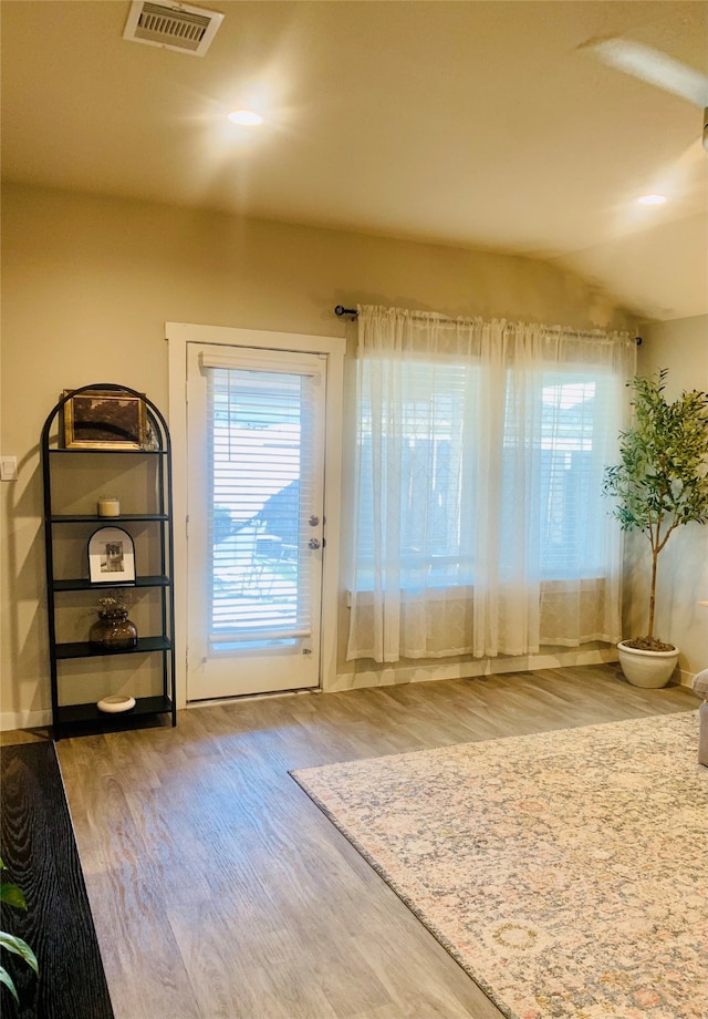 doorway to outside featuring hardwood / wood-style flooring and vaulted ceiling