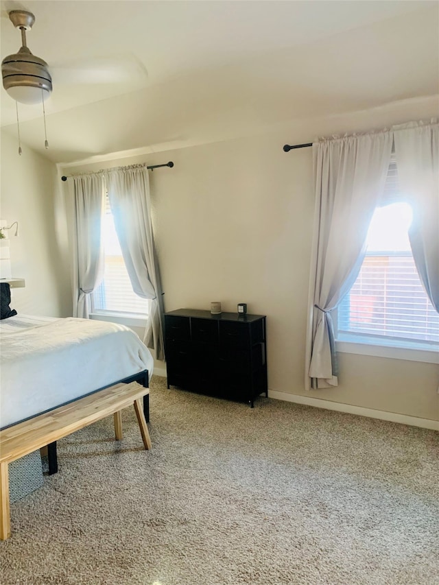 carpeted bedroom with multiple windows and ceiling fan