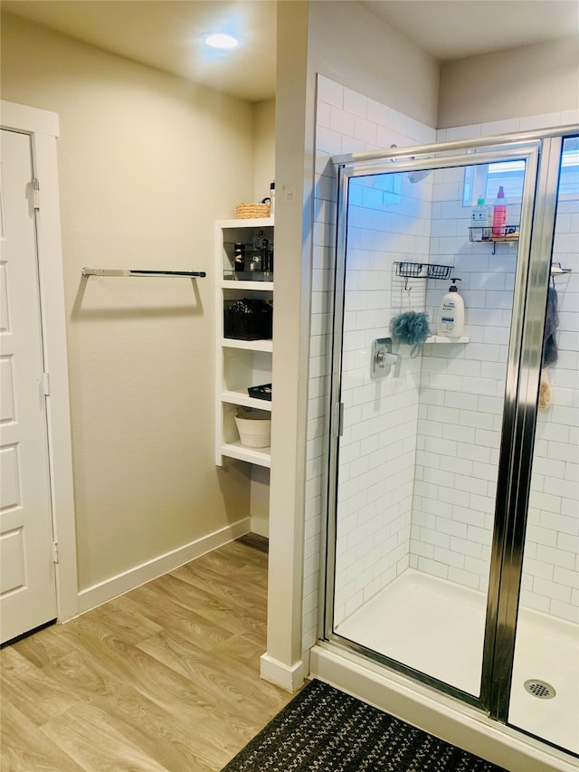 bathroom featuring hardwood / wood-style flooring and an enclosed shower