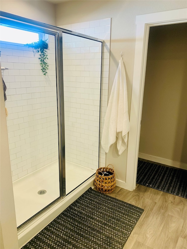 bathroom with hardwood / wood-style floors and an enclosed shower