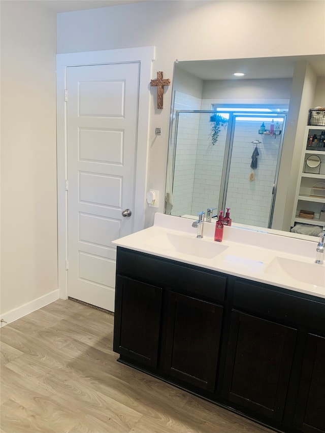 bathroom with vanity, hardwood / wood-style flooring, and a shower with door