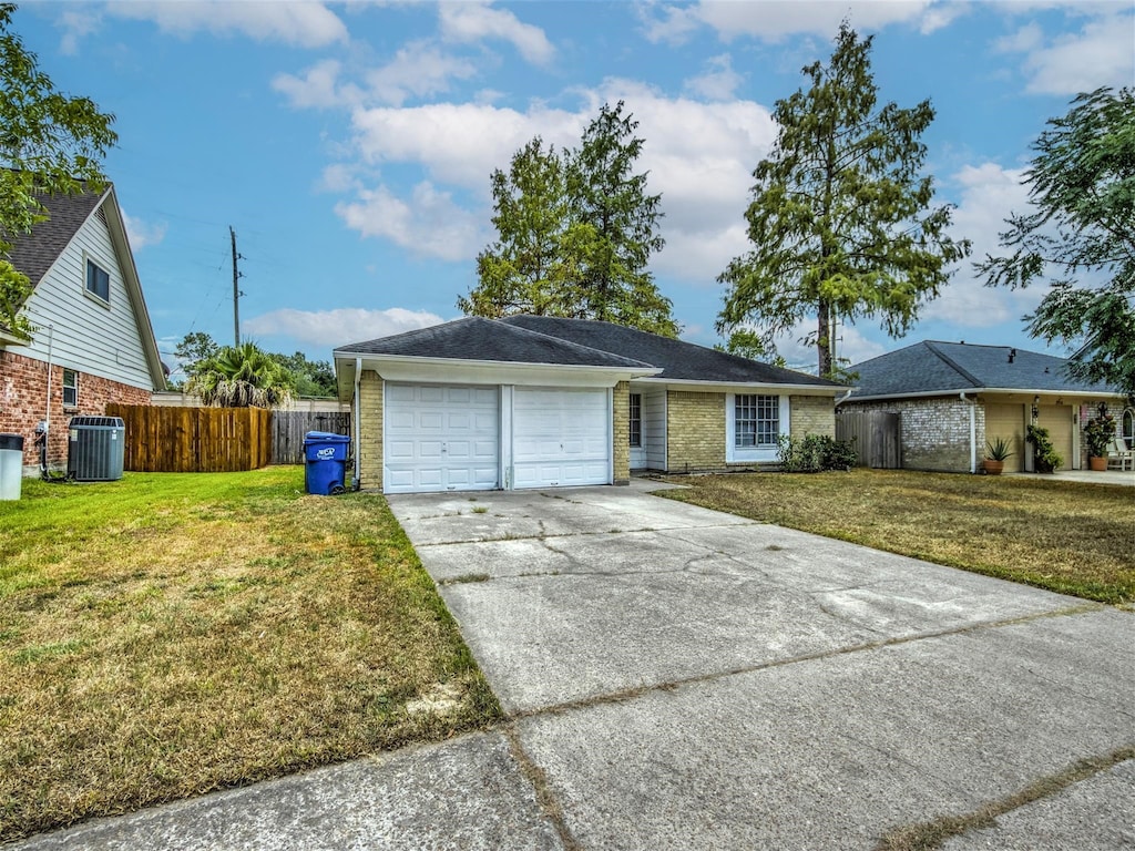 ranch-style house featuring cooling unit, a garage, and a front yard