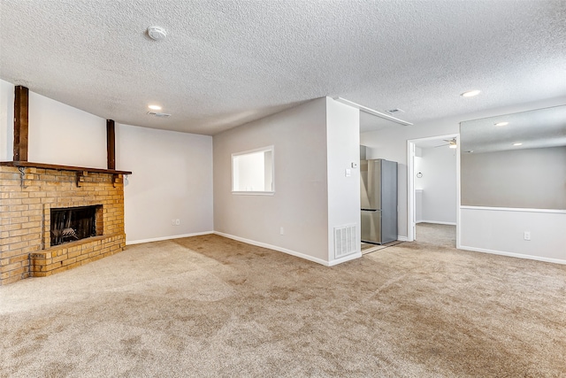 unfurnished living room with a fireplace, light carpet, a textured ceiling, and ceiling fan