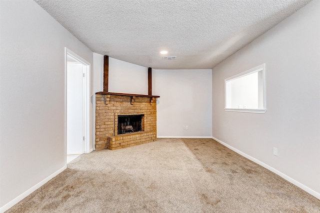 unfurnished living room featuring a fireplace, a textured ceiling, and light colored carpet