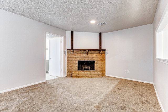 unfurnished living room with carpet flooring, a textured ceiling, and a brick fireplace