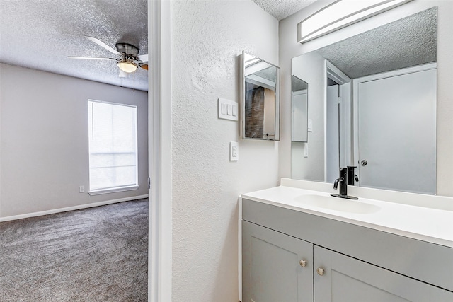 bathroom featuring ceiling fan, vanity, and a textured ceiling