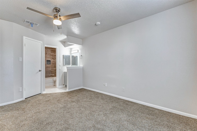 spare room featuring a textured ceiling, ceiling fan, and light carpet