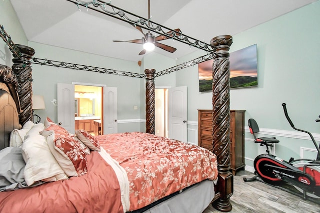 bedroom featuring ensuite bath, ceiling fan, wood-type flooring, and lofted ceiling