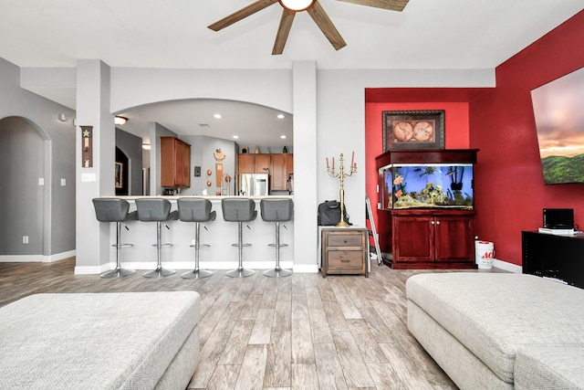 living room with light wood-type flooring and ceiling fan