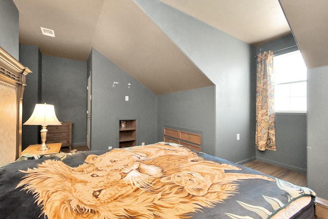 bedroom featuring hardwood / wood-style flooring and vaulted ceiling