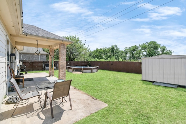 view of yard with a fenced in pool, a shed, and a patio area