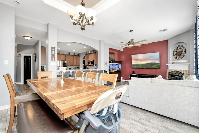 dining area featuring ceiling fan with notable chandelier