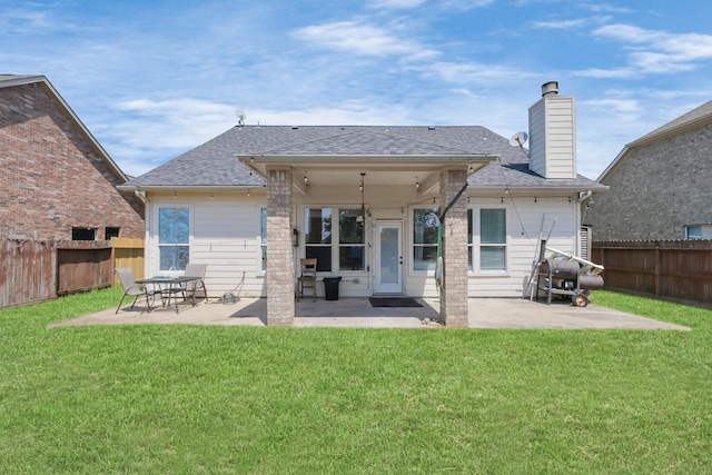 back of house with a yard and a patio