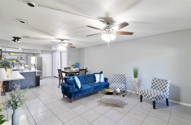 living room with ceiling fan and light tile patterned floors