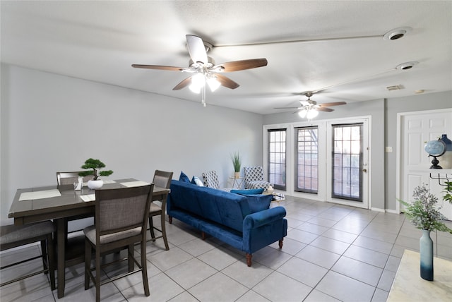 living room featuring ceiling fan, light tile patterned flooring, and a textured ceiling