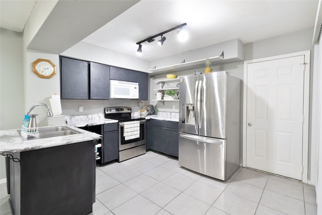 kitchen with kitchen peninsula, sink, light tile patterned floors, and stainless steel appliances