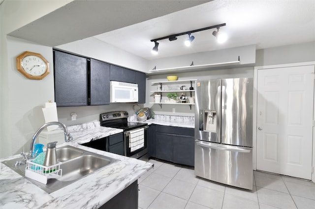 kitchen with light tile patterned floors, rail lighting, stainless steel appliances, and sink