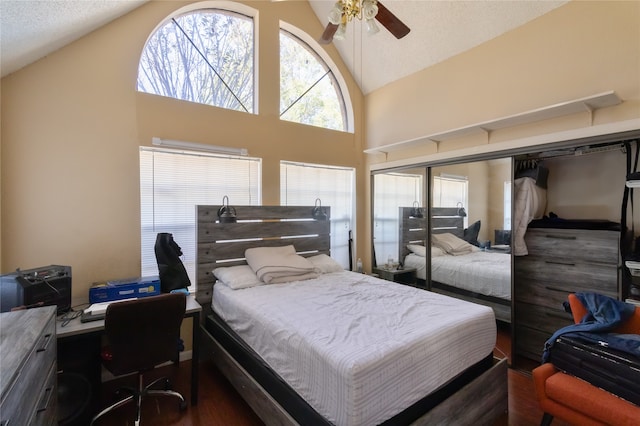 bedroom with a textured ceiling, dark hardwood / wood-style floors, high vaulted ceiling, and ceiling fan