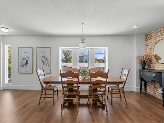 dining area with dark hardwood / wood-style flooring and a wood stove