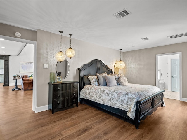 bedroom featuring connected bathroom and dark hardwood / wood-style flooring