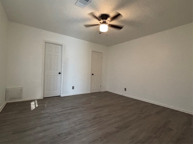 empty room with dark hardwood / wood-style floors, ceiling fan, and a textured ceiling