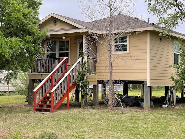 315 20th St, San Leon, TX 77539 - rear view of property featuring a yard, stairway, and a shingled roof