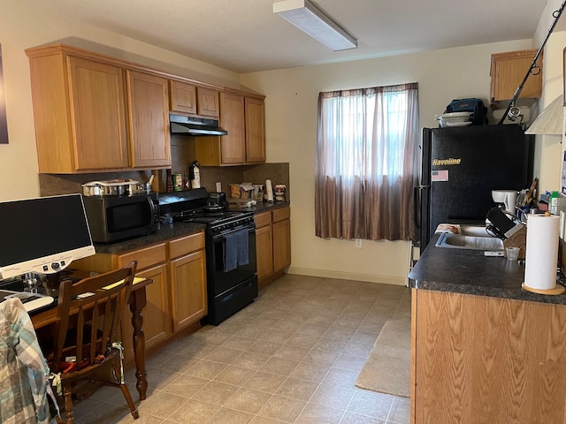 315 20th St, San Leon, TX 77539 - kitchen featuring black appliances, under cabinet range hood, dark countertops, and a sink