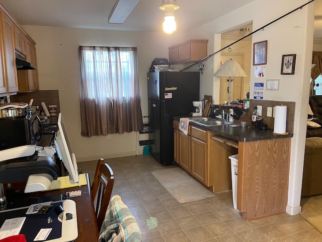 315 20th St, San Leon, TX 77539 - kitchen with black appliances, under cabinet range hood, dark countertops, light tile patterned flooring, and a sink