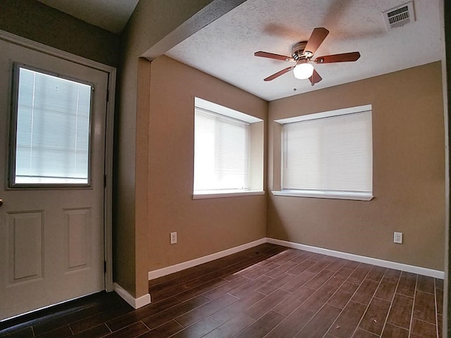 entryway with ceiling fan, dark hardwood / wood-style flooring, and a textured ceiling