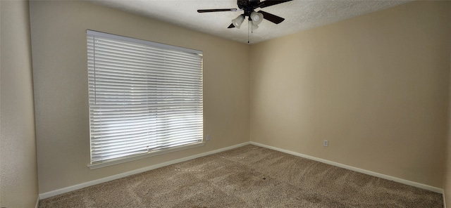 carpeted spare room with a textured ceiling and ceiling fan