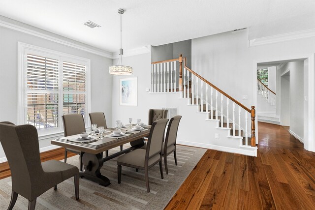 dining space with crown molding and dark wood-type flooring