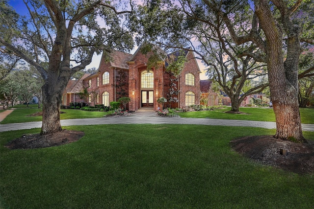 tudor house featuring french doors and a front yard