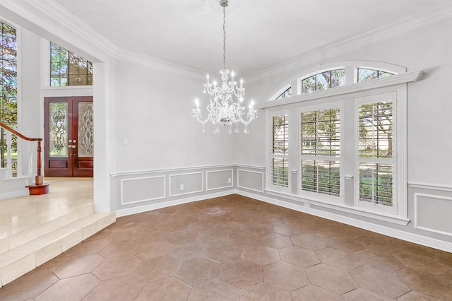 unfurnished dining area featuring tile patterned floors, ornamental molding, french doors, and a chandelier