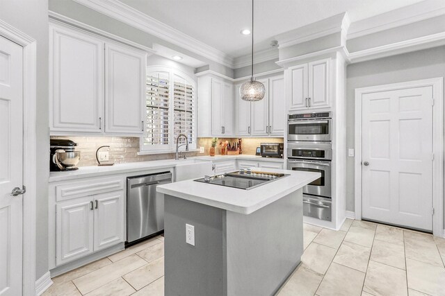 kitchen with tasteful backsplash, stainless steel appliances, decorative light fixtures, white cabinets, and a kitchen island