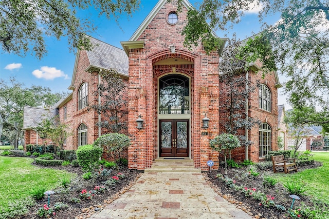 entrance to property featuring french doors and a yard