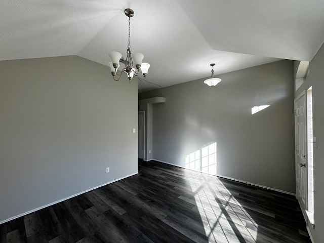 empty room featuring dark hardwood / wood-style flooring, lofted ceiling, and a wealth of natural light