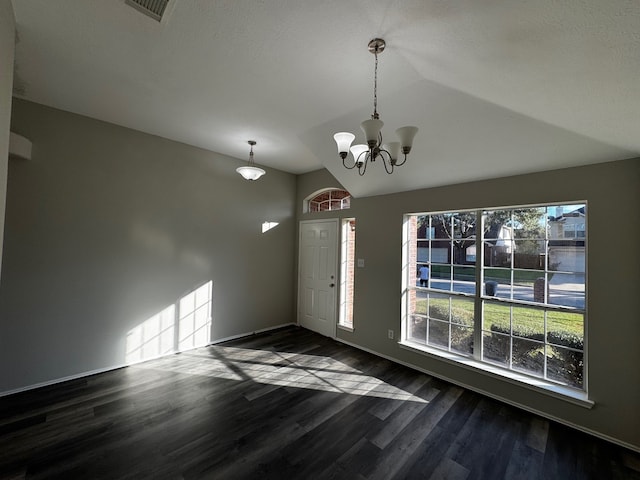 foyer entrance with a chandelier, dark wood-type flooring, and lofted ceiling