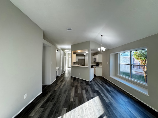 unfurnished living room featuring dark hardwood / wood-style floors, an inviting chandelier, and lofted ceiling