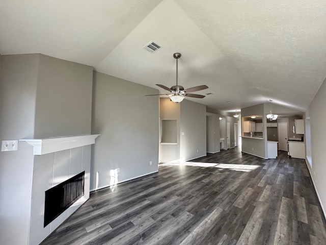 unfurnished living room with a fireplace, ceiling fan with notable chandelier, dark hardwood / wood-style floors, and lofted ceiling