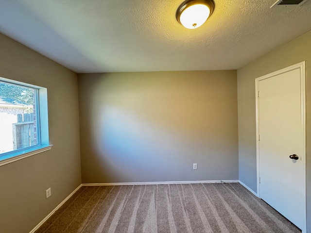 carpeted spare room with a textured ceiling