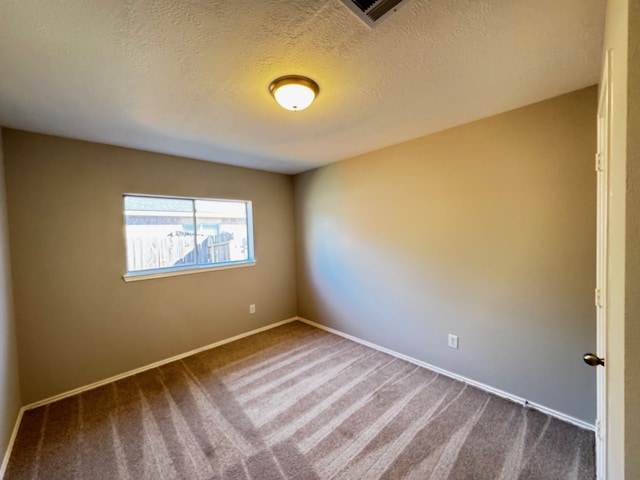 unfurnished room featuring carpet and a textured ceiling