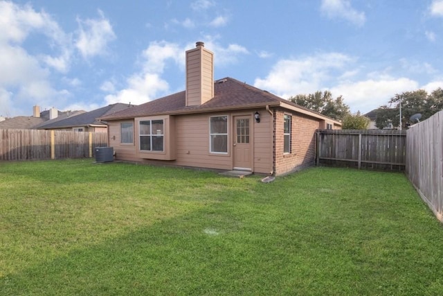 rear view of house featuring cooling unit and a lawn