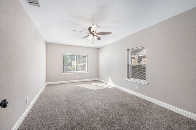 empty room with ceiling fan and carpet floors