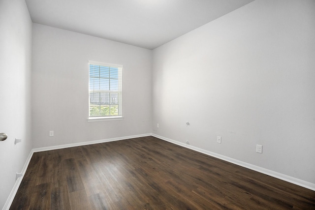 empty room with dark hardwood / wood-style flooring