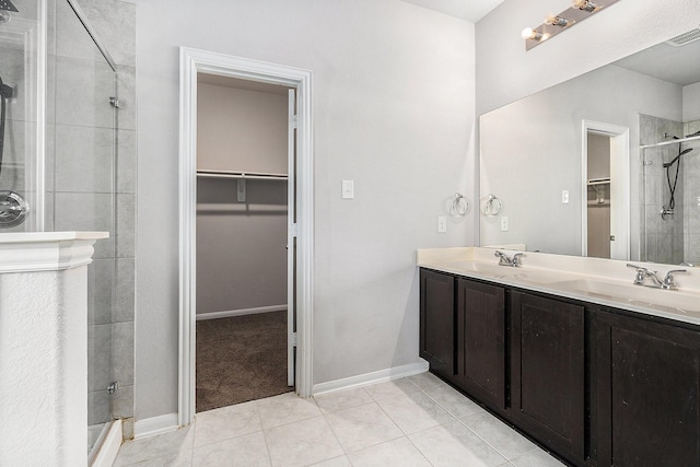 bathroom featuring tile patterned flooring, vanity, and a shower with door