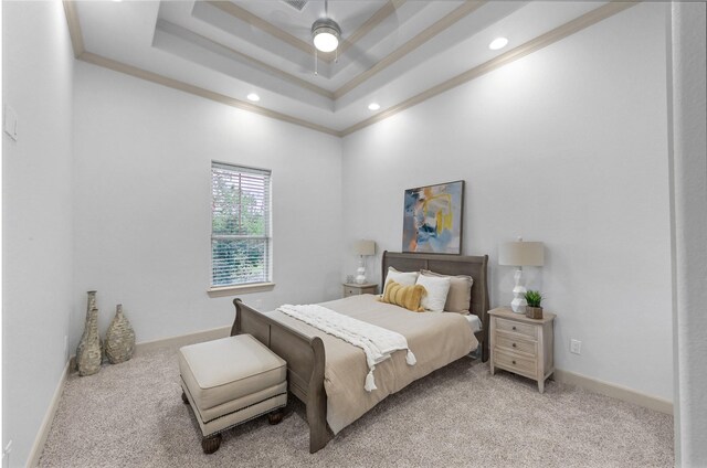 bedroom with ceiling fan, ornamental molding, light carpet, and a tray ceiling