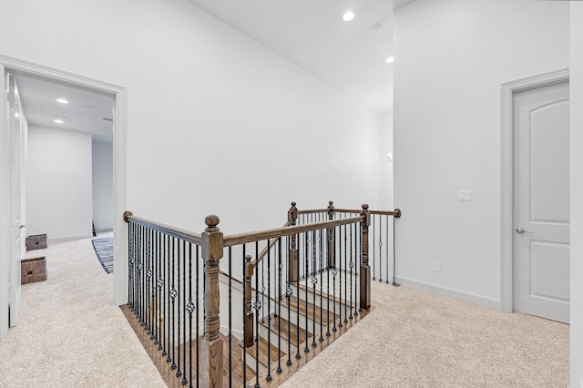 corridor featuring carpet floors, an upstairs landing, and recessed lighting