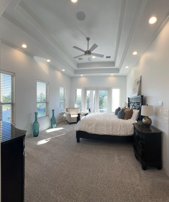 carpeted bedroom featuring ceiling fan, a raised ceiling, crown molding, and french doors