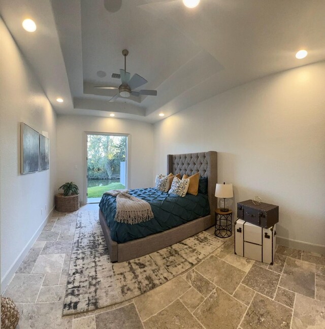 bedroom with access to outside, ceiling fan, and a tray ceiling