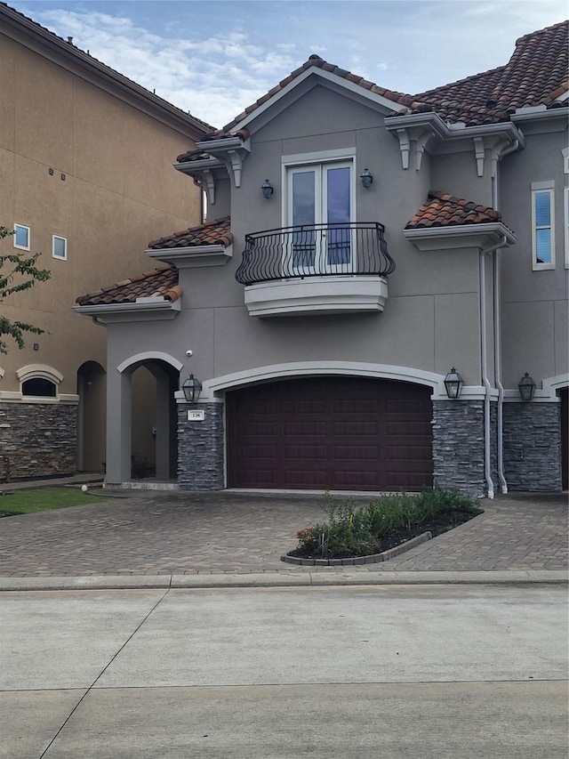 view of front of home with a garage and a balcony